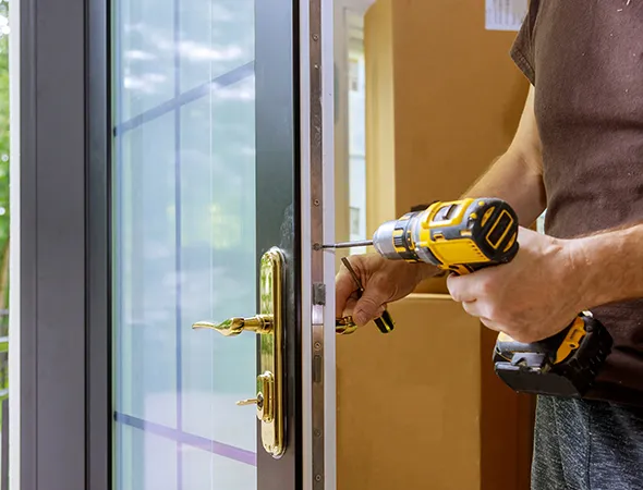 A technician replacing the lock on a patio door, ensuring enhanced security and smooth operation for the glass entryway.