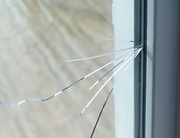 A visible crack on the windowpane, indicating damage that may affect insulation, safety, and clarity, needing timely repair.